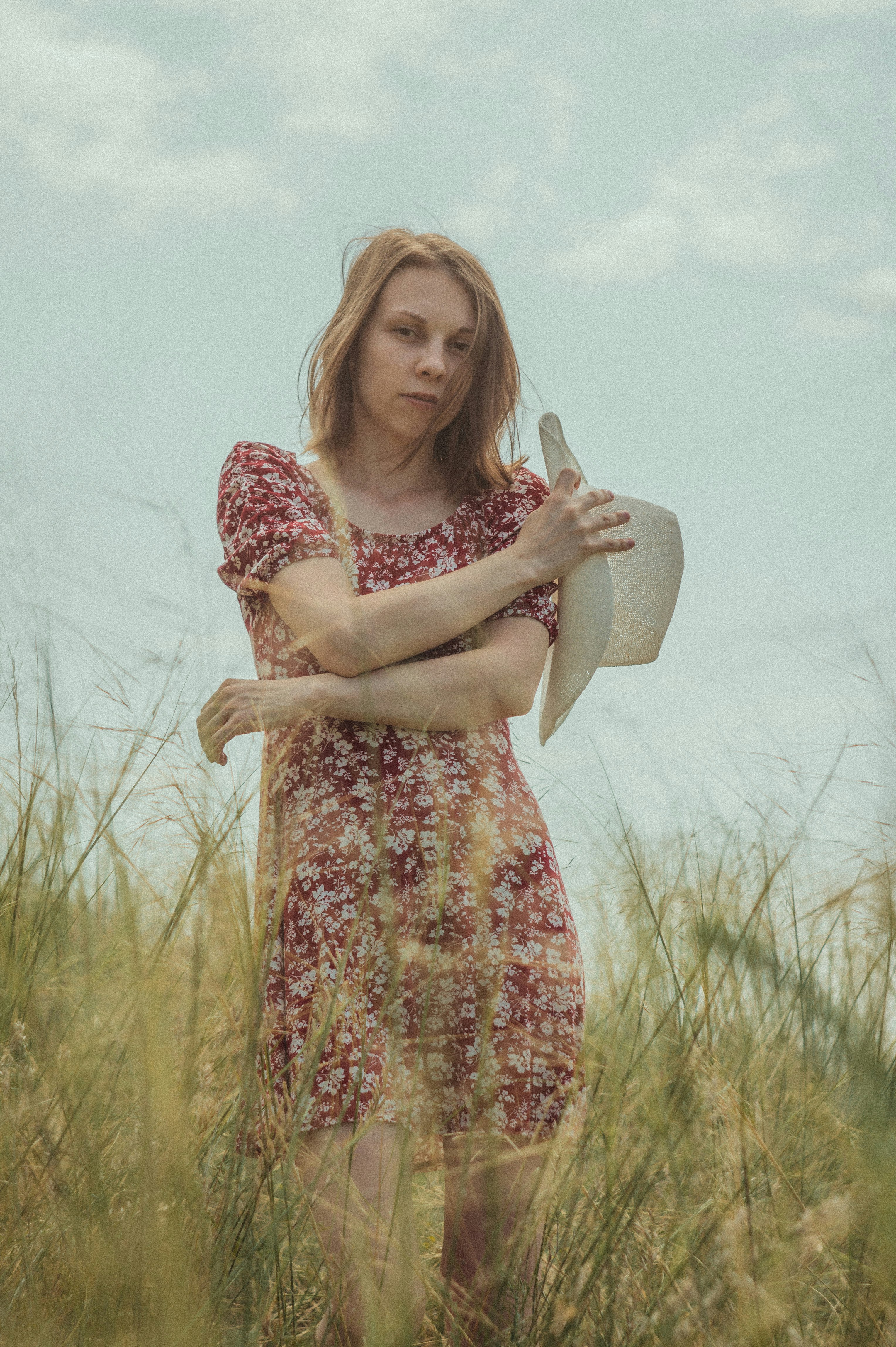 woman in red and white floral dress holding white ceramic mug